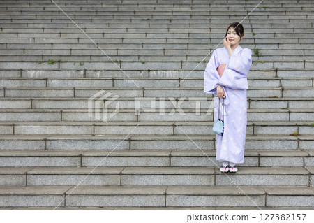 Young Japanese woman in kimono standing on the stairs Young Japanese woman in kimono standing on the stairs 127382157