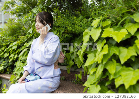 Young Japanese woman wearing kimono walking in the park 127382166