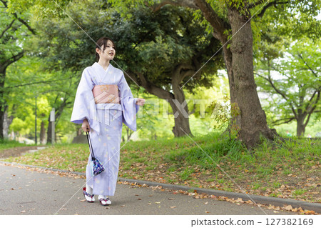 Young Japanese woman wearing kimono walking in the park Young Japanese woman wearing kimono walking in the park 127382169