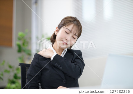 一位年輕的女商人因肩膀僵硬而感到不適 一位年輕的女商人因肩膀僵硬而感到不適 127382236