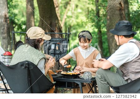 一個親密的家庭在公園和露營地享受日間露營、露營和燒烤。 一個親密的家庭在公園和露營地享受日間露營、露營和燒烤。 127382342