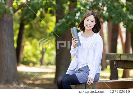 A woman rehydrating with her own bottle 127382619