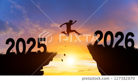 Welcome merry Christmas and Happy new year in 2026. Man jumping across the gap from 2025 to 2026 cliff with Sunset and Twilight Sky background. 127382870