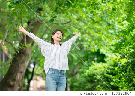 A woman relaxing in the fresh greenery A woman relaxing in the fresh greenery 127382964