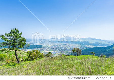 A spectacular panoramic view of Aso city with the five peaks of Mt. Aso in the background "Bungo Kaido - Futatsutoge Stone-paved Road (fresh greenery)" Aso City 127383583