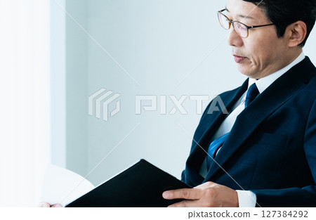 Businessmen checking materials Businessmen checking materials 127384292