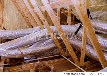 Insulated attic with exposed ductwork wooden beams during home renovation process Insulated attic with exposed ductwork wooden beams during home renovation process 127384742