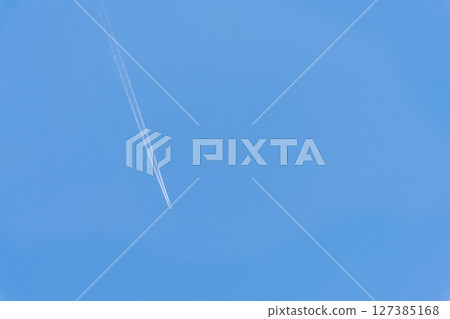 Contrails and rays of light shining in the refreshing blue sky Skyscape material (Aerial photography from around the stone-paved road of the Edo period) Aso City 127385168