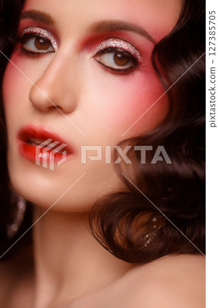 Portrait of elegant brunette woman with red eye makeup on dark background, front view 127385705