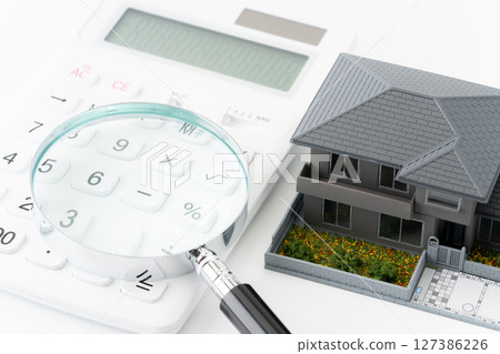 Calculator, magnifying glass and miniature detached house 127386226