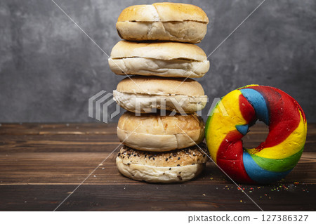 Closeup view of a pile of a collection of bagel breads with various kinds on a wooden board 127386327