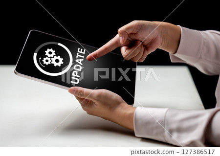Businesswoman showing an update icon on the tablet screen. Technology innovation on a virtual screen. Concept of software update Businesswoman showing an update icon on the tablet screen. Technology innovation on a virtual screen. Concept of software update 127386517