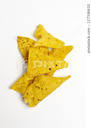 Heap of nachos tortilla chips on a white background. Food and snacks concept Heap of nachos tortilla chips on a white background. Food and snacks concept 127386610