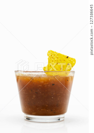 Nachos tortilla chips on salsa barbecue sauce in a glass bowl on a white background. Food and snacks concept Nachos tortilla chips on salsa barbecue sauce in a glass bowl on a white background. Food and snacks concept 127386645