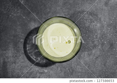 Closeup view of matcha green tea on the glass on the black table. Top view 127386653