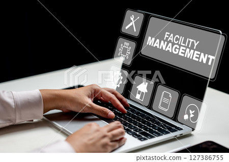 Businesswoman using a laptop and showing a facility management icon. Tablet on the table. Technology innovation on a virtual screen. Concept of facility management 127386755