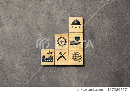 Wooden cubes with an HSE sign on a black background. Abbreviation of Health, Safety, and Environment. Industry standardization of a safe, healthy, and good environment 127386757