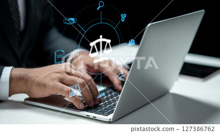 Businessman using a laptop and showing a judge scale icon. Tablet on the table. Technology innovation on a virtual screen. Concept of law, justice, legal services, and business legislation 127386762