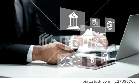 Businessman using a laptop and tablet and showing an icon of a financial loan scheme. Technology innovation on a virtual screen. Concept of a financial loan Businessman using a laptop and tablet and showing an icon of a financial loan scheme. Technology innovation on a virtual screen. Concept of a financial loan 127386763