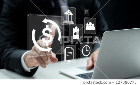 Businessman using a laptop while touching a currency icon. Technology innovation on a virtual screen. Concept of payroll Businessman using a laptop while touching a currency icon. Technology innovation on a virtual screen. Concept of payroll 127386773