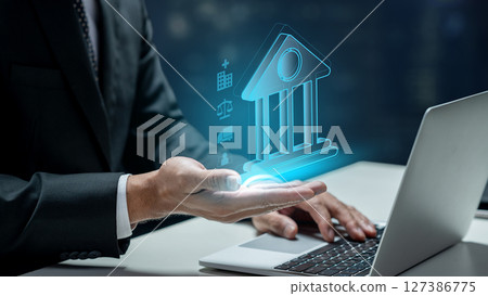 Businessman using a laptop while showing a government icon. Technology innovation on a virtual screen. Concept of public sector governance 127386775