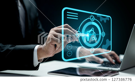 Businessman using a laptop while touching a robotic arm and a gear icon. Tablet on the table. Technology innovation on a virtual screen. Concept of robotic process automation 127386776