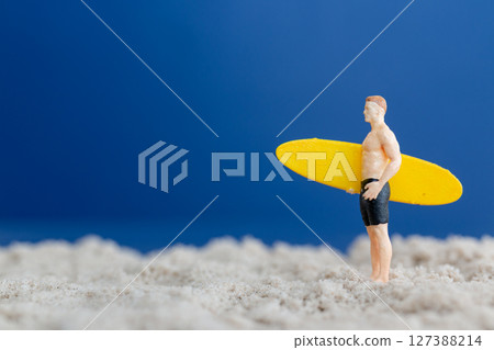 Mini Surfer with Yellow Board Standing on Sand Mini Surfer with Yellow Board Standing on Sand 127388214