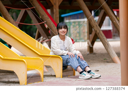 Girls playing with park play equipment 127388374