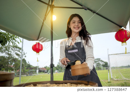 Indonesian southeast chinsese asian female waiter prepare serving food for her customer. A small business on a truck Indonesian southeast chinsese asian female waiter prepare serving food for her customer. A small business on a truck 127388647