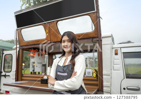 Indonesian southeast asian female barista standing with confidence in front of his coffee shop. A small business of a coffee shop or cafe on a truck 127388795