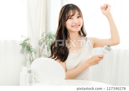 Young asian woman using massage roller on arm at home 127390276