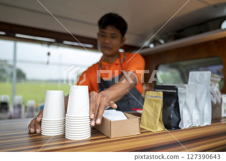 Indonesian southeast asian male barista preparing his coffee shop before opening the order. A small business of a coffee shop or cafe on a truck 127390643