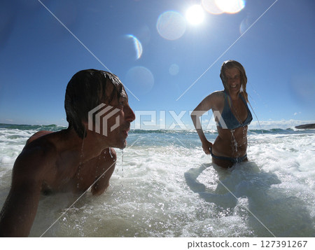 Ocean waves splashing on a romantic couple 127391267