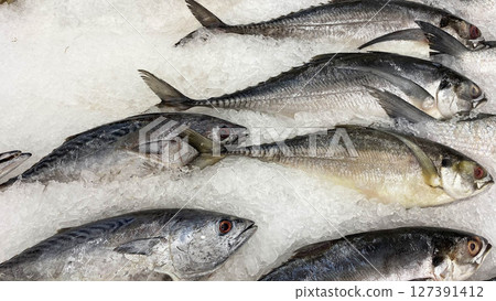 Freshly caught sea fish displayed on a bed of crushed ice at a seafood market. Suitable for culinary, food industry, seafood trade, or nutrition-related themes. 127391412