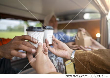 Chinese muslim female in hijab barista serving drinks and snacks to customers. A small business of a coffee shop or cafe on a truck 127391492