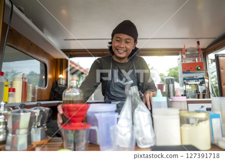 Indonesian southeast asian male barista preparing his coffee shop before opening the order. A small business of a coffee shop or cafe on a truck 127391718