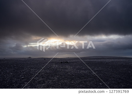 Panoramic view of black sand beach and mountain range landscapes with dramatic sky on Solheimasandur, Iceland. Nature, travel, winter background, or wallpaper 127391769
