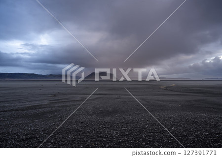 Panoramic view of black sand beach and mountain range landscapes with dramatic sky on Solheimasandur, Iceland. Nature, travel, winter background, or wallpaper 127391771