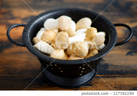 Fresh raw Eringi or King Trumpet mushrooms on a wooden table. Fresh raw Eringi or King Trumpet mushrooms on a wooden table. 127392289