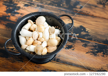 Fresh raw Eringi or King Trumpet mushrooms on a wooden table. 127392290