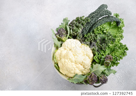 Different kinds of fresh organic cabbage on a gray concrete background. Green and Purple Kale, Broccoli, Savoy Cabbage, Cauliflower, Black Cabbage. Healthy diet food. Different kinds of fresh organic cabbage on a gray concrete background. Green and Purple Kale, Broccoli, Savoy Cabbage, Cauliflower, Black Cabbage. Healthy diet food. 127392745