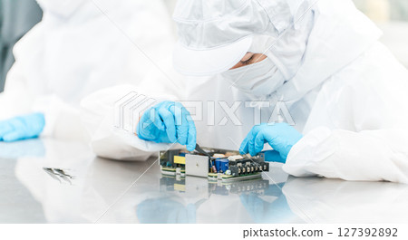 Female handling precision equipment in a clean room Female handling precision equipment in a clean room 127392892