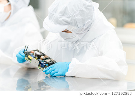 Female handling precision equipment in a clean room 127392893