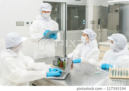 Staff wearing clean suits developing drugs at a pharmaceutical factory or pharmaceutical company 127393194