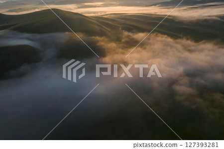 Aerial drone view of foggy sunrise over hills 127393281