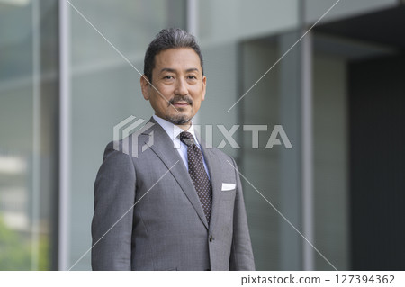 A businessman in his late 50s looking at the camera 127394362