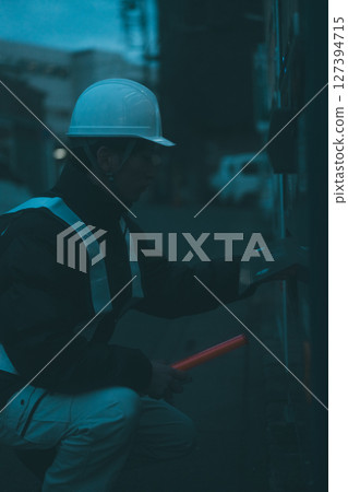 休息中的一名保全將手伸進自動販賣機的分配器 休息中的一名保全將手伸進自動販賣機的分配器 127394715
