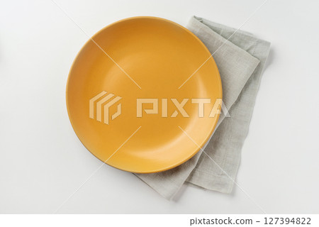 Yellow ceramic plate on a white background. 127394822