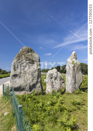 Alignments de Carnac standing stones in Brittany, France, creating a mystical atmosphere under a vibrant blue sky 127395033