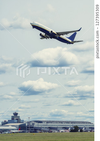 Jet plane flying over airport buildings with cloudy sky in Hostivice, Czechia Jet plane flying over airport buildings with cloudy sky in Hostivice, Czechia 127395309